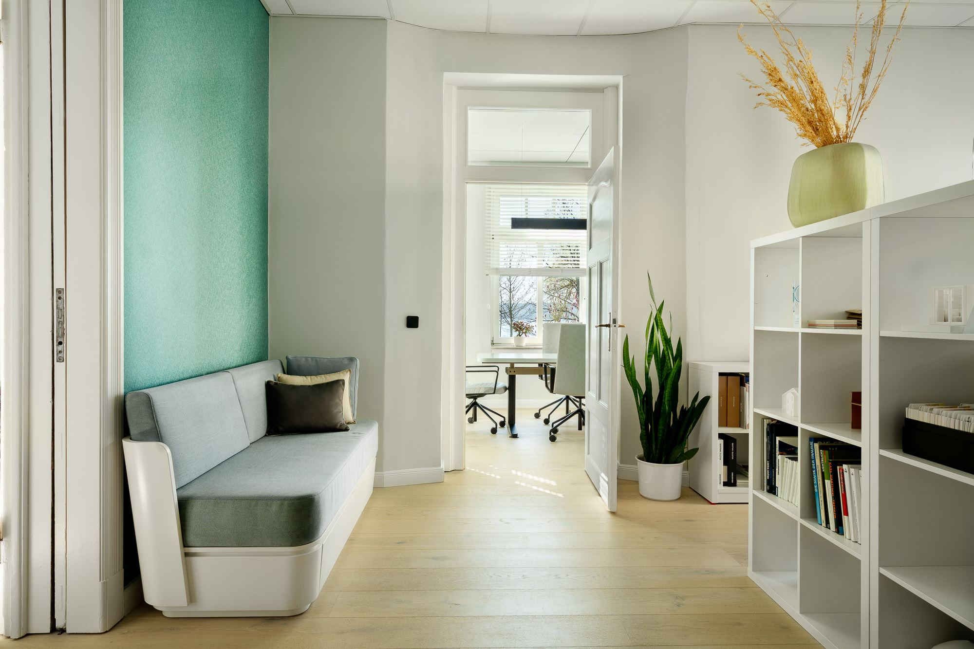 Flur im Büro mit Sitzbank, Regal und Blick in den Besprechungsraum