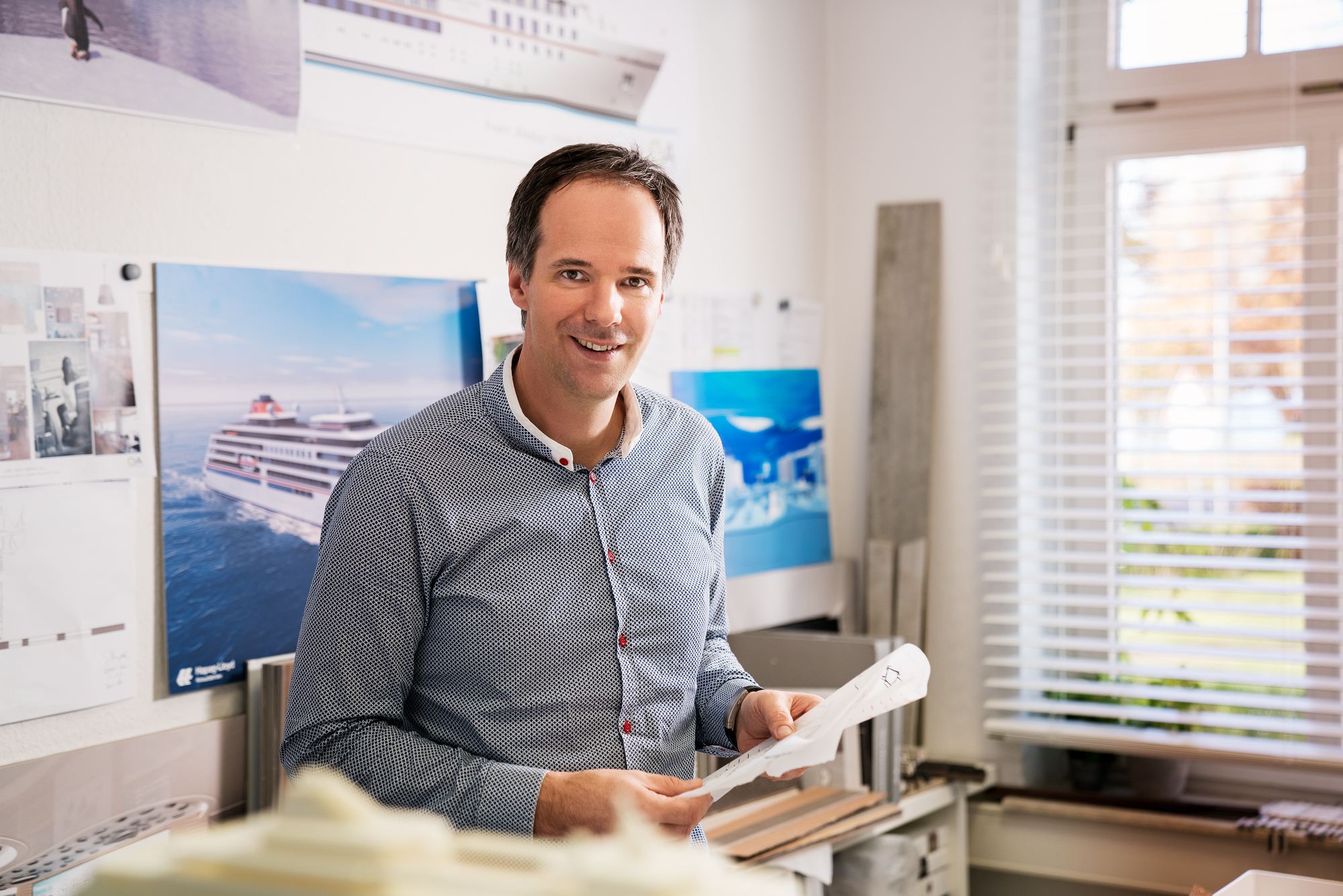 Christian Klein im Büro, mit einem Plan in der Hand